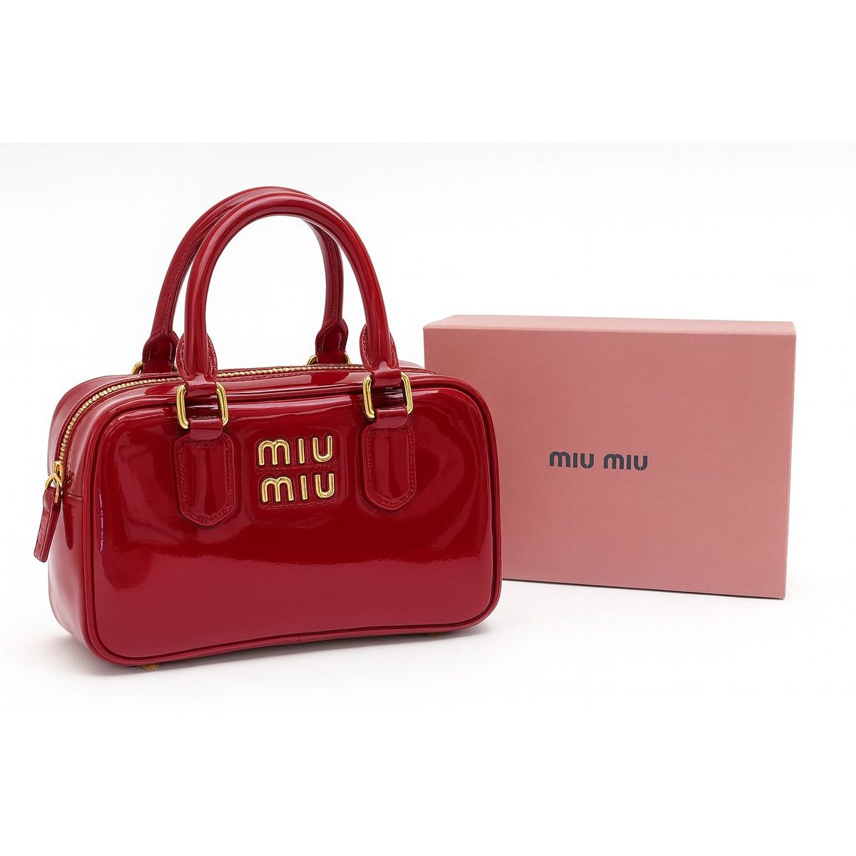 حقيبة Miu Miu باللون الأحمر اللامع مزوّدة بشعار ذهبي.