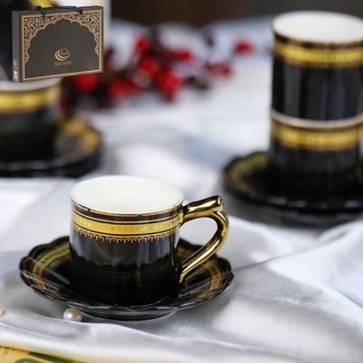 طقم فناجين قهوة بورسلان اسود حز مع يد ونقش من الاعلى ذهبي 12 فنجان + 12 صحن شكل وردة