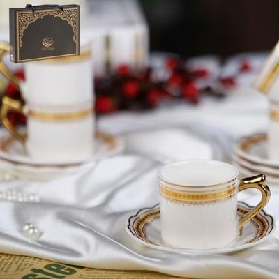 طقم فناجين قهوة بورسلان ابيض حز مع يد ونقش من الاعلى ذهبي 12 فنجان + 12 صحن شكل وردة